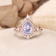 a ring with an amethorate surrounded by white diamonds and pink sapphires