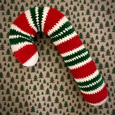 a pair of red and green knitted mittens laying on top of a wall