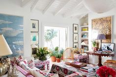 a living room filled with lots of furniture next to a painting on the wall above a table