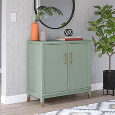 a living room with a green cabinet and potted plant