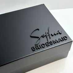 a black box with the words sofira bridesmaid on it sitting on a white surface