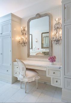 a white dressing table with a mirror and chandelier