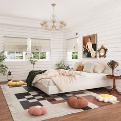 a living room with white walls and wood flooring is furnished with an overstuffed bed