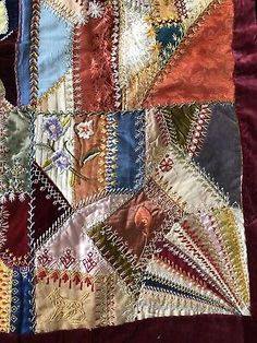 an old piece of cloth with many different colors and designs on the fabric, including red velvet