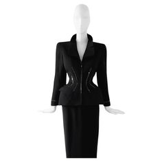 The Iconic Thierry Mugler FW 1998 jacket famously captured by the legend Helmut Newton! Extremely rare and documented piece, Museum Worthy. Black jacket and long black skirt ensemble. Stunning fitted blazer jacket with crystal rhinestone details at the waist and cuffs. Beautiful mugleresque feminine sculptural shape, fitted waist and extraordinairy architectual collar. Excellent creation of the amazing Thierry Mugler. Closes with hidden zipper at the front. Long black skirt that closes with zipper on the back. Documented collectors piece, worn on the 1998 Runway Show, also worn by Estella Warren,Harper's Bazaar 1998 and of course photographed as fine art print in black and white by Helmut Newton. This truly is wearable Art. Extremely rare collectors piece. Made in France jacket marked vint Black Long Sleeve Skirt Suit For Evening, Formal Black Long Sleeve Skirt Suit, Black Long Sleeve Skirt Suit For Formal Occasions, Black Long Sleeve Skirt Suit For Party, Winter Black Fitted Skirt Suit, Fitted Black Skirt Suit For Winter, Estella Warren, Long Black Skirt, Rhinestone Skirt