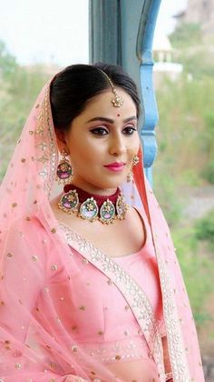 a woman wearing a pink sari and jewelry