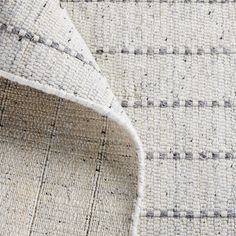 an upholstered area rug with grey and white lines on it, closeup