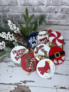 decorated christmas cookies on a table next to pine cones and evergreen branches with holiday sayings