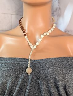 Embrace your boho chic style with this elegant handmade beaded wrap crochet necklace. Featuring a stunning combination of creamy white pearls and classic wood beads, this versatile accessory is perfect for any occasion, from casual outings to special events. The intricately crocheted wrap design adds a unique touch, ensuring you stand out from the crowd. Lightweight and comfortable to wear, this necklace makes an ideal gift for friends, family, or yourself. Enhance your jewelry collection with this timeless piece! This simple design makes it easy to dress up or down for any occasion. measuring 22 inches this beautiful necklace will make a fantastic addition to your wardrobe. *My goal is to make sure you receive exactly what you're looking for and for your experience to be a special and mem Bohemian Beaded Necklaces As Gift, Adjustable Beige Beaded Necklaces With Wooden Beads, Adjustable Beige Beaded Necklace With Wooden Beads, Bohemian Beaded Necklace With Natural Variations, Adjustable Natural Beaded Necklace, Adjustable Beige Wooden Beaded Necklaces, Beach Beaded Necklaces With Wooden Beads In Beige, Beige Wooden Beaded Necklaces For The Beach, Beige Wooden Beaded Necklaces For Beach