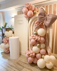 balloons are arranged in the shape of a christmas tree with bows and ribbons on them