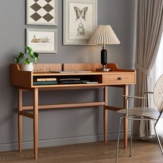 a desk with a lamp and pictures on the wall above it in a living room