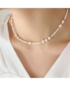 a woman wearing a necklace with pearls on it