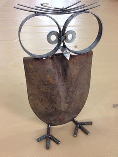 an owl made out of metal sitting on top of a table