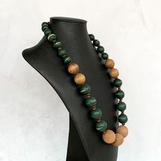 This unique boho necklace was hand beaded using a mix of distressed forest green and toffee brown wooden beads.  A super stylish casual look!  The necklace measures 26 inches in length and is securely fastened with a silver clasp.  This unisex piece is perfect for anyone looking to elevate their accessories game!  Length can be adjusted if needed - just ask! Wood represents a sense of earthiness, spirituality, creativity, liberty, prosperity, health, and natural touch.  Perfect for meditation, p Adjustable Green Rustic Necklace, Adjustable Rustic Green Necklace, Nature-inspired Green Jewelry With Wooden Beads, Green Bohemian Jewelry With Wooden Beads, Traditional Green Beaded Necklaces With Wooden Beads, Adjustable Green Beaded Necklace With Wooden Beads, Traditional Green Beaded Necklace With Wooden Beads, Artisan Green Jewelry With Wooden Beads, Earthy Wooden Beaded Necklaces