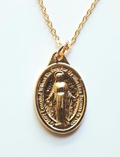 This beautiful gold finished Miraculous Medal is a low cost option for those ladies who prefer to wear gold colored jewelry. The delicate gold finished chain is 18" long, with a lobster jewelry clasp. The medal is approximately one inch tall, which is the standard size for a Miraculous Medal. This pretty piece will keep its bright finish longer if you take it off before showering and freshen it up with jewelry cleaner. The Miraculous Medal was brought to us by Saint Catherine Laboure in 1832, af Catherine Laboure, Lobster Jewelry, Miraculous Medal Necklace, Saint Catherine, Colored Jewelry, Catholic Priest, St Catherine, Jewelry Clasps, Miraculous Medal