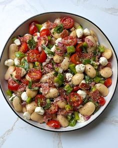 a white bowl filled with lots of food on top of a table