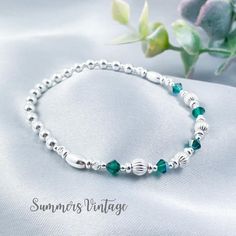 This dainty solid .925 sterling silver bracelet featuring Swarovski Emerald crystals makes the ideal gift for those who celebrate their birthday in May  May is represented in the Swarovski birthstone chart as an Emerald, a deep rich green crystal that symbolizes love, wealth, and happiness  The eclectic mix of sterling silver beads are strung on high quality, strong, professional jewellers' elastic meaning there are no fiddly clasps to deal with, simply roll the bracelet over your hand, and onto your wrist The bracelet comes presented in a beautiful grey faux suede jewellery pouch along with aftercare instructions and a cleaning cloth ☽ SIZE: Available in wrist sizes: Small (17cm), Medium (18cm) or Large (19cm) If you're unsure about sizing please drop me a message and I'll be more than ha Silver Sterling Beaded Bracelets For Birthday, Adjustable Sterling Silver Bracelet For Birthday, Classic Silver Bracelets With Birthstone, Adjustable Sterling Silver Bracelet With Birthstone For Anniversary, Adjustable Silver Beaded Bracelet For Anniversary, Classic Silver Birthstone Bracelets, Classic Silver Bracelet With Birthstone, Handmade Elegant Beaded Bracelets For Birthday Gift, Elegant Handmade Beaded Bracelets For Birthday Gift