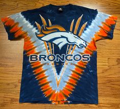 a tie - dye shirt with the denver rams on it is laying on a wooden floor