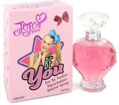 a bottle of perfume sitting next to a pink box on a white background with the words be you