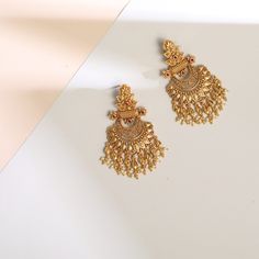 Description Inspired by the shimmering Indian gold jewelry. This Collection is designed to highlight fine Indian craftsmanship. It is crafted in gold-plated 925 silver with intricate textures and tones. Modern designs adorn you with timeless floral patterns. This jewelry is perfect for wedding and festival events. Glistening with festive elegance, these leafy floral silver chandbali earrings are a timeless piece made with traditional Indian design aesthetics. The design features a central floral 22k Gold Meenakari Earrings For Celebrations, 22k Gold Danglers For Wedding And Diwali, 22k Gold Wedding Danglers For Diwali, 22k Gold Chandbali Bridal Earrings With Latkans, Temple Style 22k Gold Bridal Drop Earrings, Temple Jewelry Style Bridal Drop Earrings In 22k Gold, Temple Jewelry Bridal Drop Earrings In 22k Gold, Gold Meenakari Drop Earrings, 22k Gold Chandbali Bridal Earrings