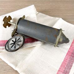 an old fashioned kitchen gadget with a clock on it's side sitting on top of a napkin