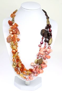 Behold the aura of beaded bliss emanating from this tri-colored Garnet, Amber, and Carnelian necklace. A cluster texture, from smooth to faceted beads of Carnelian, Citrine, Pink Coral, Garnets, and dyed Freshwater Pearls cascade throughout the necklace. Further enhanced by 24K Gold Vermeil beads, the elegant combinations of soft pastel colors are sure to bring out your flawless feminine features. Measures approximately 22 inches in length. Secures with a Vermeil Toggle Closure Gift Boxed. Garne Luxury Carnelian Beaded Necklace With Natural Stones, Luxury Amber Necklace With Gemstone Beads, Luxury Carnelian Beaded Necklace, Luxury Amber Beaded Necklaces With Oval Beads, Luxury Orange Agate Necklace, Luxury Carnelian Gemstone Beads Necklace, Luxury Handmade Orange Necklaces, Luxury Amber Carnelian Beaded Necklaces, Luxury Amber Gemstone Beads Jewelry