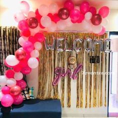 balloons and streamers decorate the entrance to a room decorated with gold, pink and silver decorations