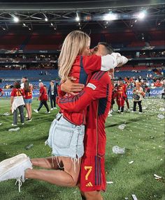 two women embracing each other on the field at a soccer game with confetti all around them