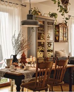 the dining room table is set for two with candles on it and decorations hanging from the ceiling