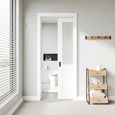 a bathroom with white walls and flooring next to an open door that leads to a toilet