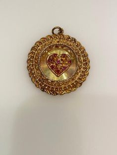 Vintage 14k yellow gold ruby heart round filigree disc with rope edge charm. The charm is 14.98 grams of gold. Collectible 14k Gold Heart-shaped Jewelry, Collectible Gold Jewelry With Heart Charm, Victorian Yellow Gold Jewelry For Valentine's Day, Valentine's Day Engraved Medallion Jewelry, Ornate Vintage Charm Round Pendant Jewelry, Victorian 14k Gold Jewelry For Valentine's Day, Hallmarked Medallion Jewelry For Valentine's Day, Victorian Medallion Jewelry For Valentine's Day, Collectible Medallion Jewelry For Valentine's Day