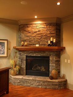 a living room with a stone fireplace and wood flooring in front of a painting on the wall