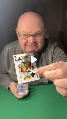 a man holding up a playing card in front of his face