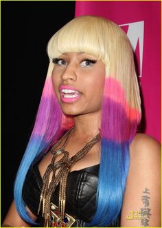 a woman with pink and blue hair is posing for the camera