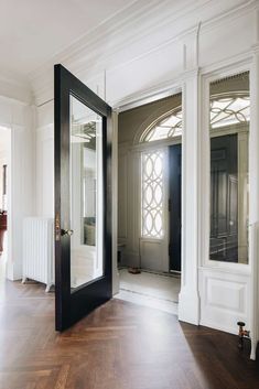 an empty room with a large mirror on the wall and wooden floors in front of it