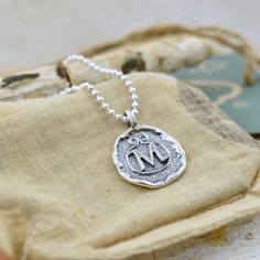 An initial or monogram is a sign of identity. Wear it to show off your own beautiful identity or wear several to show off those who have created a lasting impression in your heart. Our Lasting Impressions Necklace comes to you in handcrafted sterling silver and on a 16" chain. If you prefer a longer length, you can select 18, 20, 24 or 30 inches for a small additional fee. This designer monogram necklace replicates the the lost art of wax seals to identify the writer. Each silver monogram is cre Symbolic Stamped Necklace For Anniversary, Classic Sterling Silver Monogram Charm Necklace, Sterling Silver Monogram Charm Necklace For Mother's Day, Classic Monogram Sterling Silver Charm Necklace, Sterling Silver Medallion For Personalized Gift, Personalized Medallion Jewelry In Sterling Silver, Personalized Sterling Silver Medallion Jewelry, Personalized Adjustable Sterling Silver Initial Necklace, Silver Monogram Jewelry For Everyday