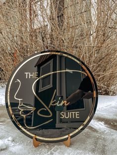 a sign that says the skin suite in front of some snow covered trees and bushes