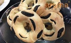 several bagels are stacked on top of each other in a glass dish with black sprinkles