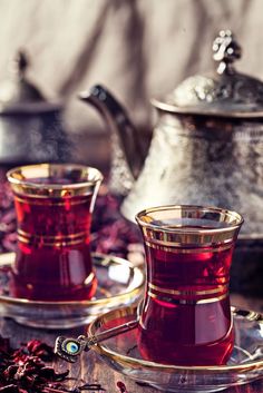 two tea cups and saucer sitting on a table