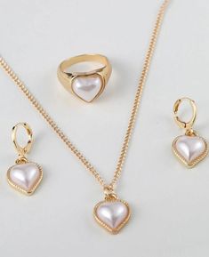 It's a 4pc heart shaped white pearl and gold plated earrings,ring and necklace in jewelry set. Elegant Heart Cut Jewelry Sets For Gift, Heart-shaped Jewelry Sets For Wedding And Mother's Day, Elegant Heart-shaped Jewelry Sets For Anniversary, Elegant Heart Pendant Jewelry Set For Valentine's Day, Elegant Heart-shaped Metal Jewelry Sets, Heart Shaped Pearl Drop Jewelry For Parties, Heart-shaped Pearl Drop Jewelry For Parties, Elegant Heart Shaped Jewelry Set For Mother's Day, Elegant Heart Cut Jewelry Sets