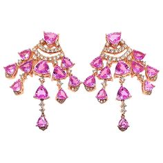 Sunita Nahata presents an exclusive collection of pink sapphire earrings. This particular earring showcases dangling sapphires and diamonds, and is constructed to fall elegantly on the wearer. Designer pink sapphire earring in 18K rose gold with diamonds. Pink Sapphire: 10.53 carat in various sizes of trillion shapes. Diamonds: 0.81 carat, G colour, VS clarity. Gold: 10.704g, 18K rose gold. Astrid Leong, Christmas Smoothies, Rose Gold Chandelier, Rose Gold Chandelier Earrings, Sapphire Earring, Red Garnet Earrings, Pink Sapphire Earrings, Gold Chandelier Earrings, Sapphire And Diamond Earrings