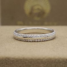 a wedding band is sitting on top of a box with a gold and diamond ring