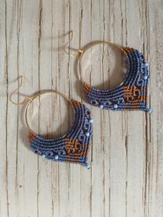 two pairs of beaded hoop earrings sitting on top of a wooden table