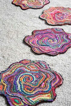 three rugs that are on the ground with different colors and shapes in them,