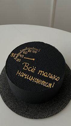 a black cake with gold writing on it