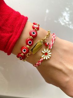 Three different March Bracelets in red - wihte - gold colors. The first bracelet has a row of red evil eyes and gold metal beads, the second one is a gold bar with a red evil eye on it, and the last one a really special red and white cord with a special flower that is made from enamel . Wear a March and dont afraid to get burned from the sun. Wear them all together or separetely as well. Find them only at Christina Christi. MATERIALS - Red and White Cord with a flower at the center that is made Spring Bracelets, Lingot D'or, Bracelets Red, Bracelet Evil Eye, Preppy Jewelry, Spring Bracelet, Word Bracelet, Floral Bracelet, Women's Bracelets