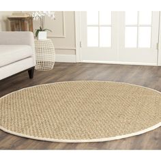 a living room with a white couch and large rugs on the wooden flooring