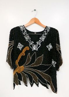 The Black Beaded Sequin Cocktail Tunic Formal Beaded Tops For Summer, Vintage Embroidered Tops For Parties, Vintage Embroidered Party Tops, Fitted Black Beaded Blouse, Festive Beaded Tops For Night Out, Black Beaded Blouse For Party, Fitted Beaded V-neck Blouse, Fitted Beaded Top For Festive Season, Festive Fitted Beaded Top