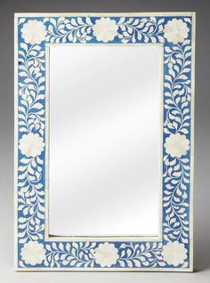 a blue and white mirror with flowers on it