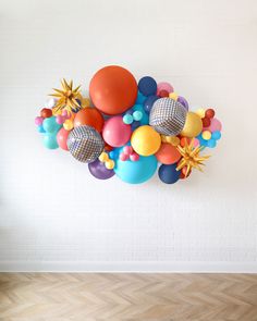 a bunch of balloons are hanging on the wall